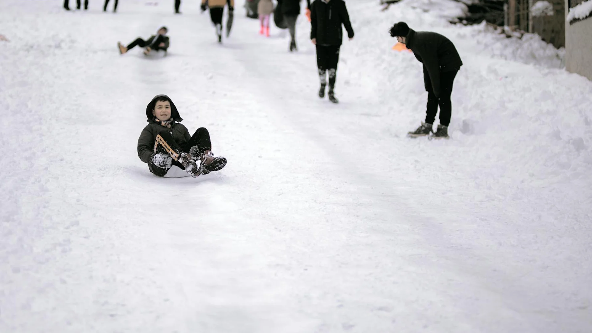 Famille profitant d'activités de luge sur pistes enneigées en station de ski