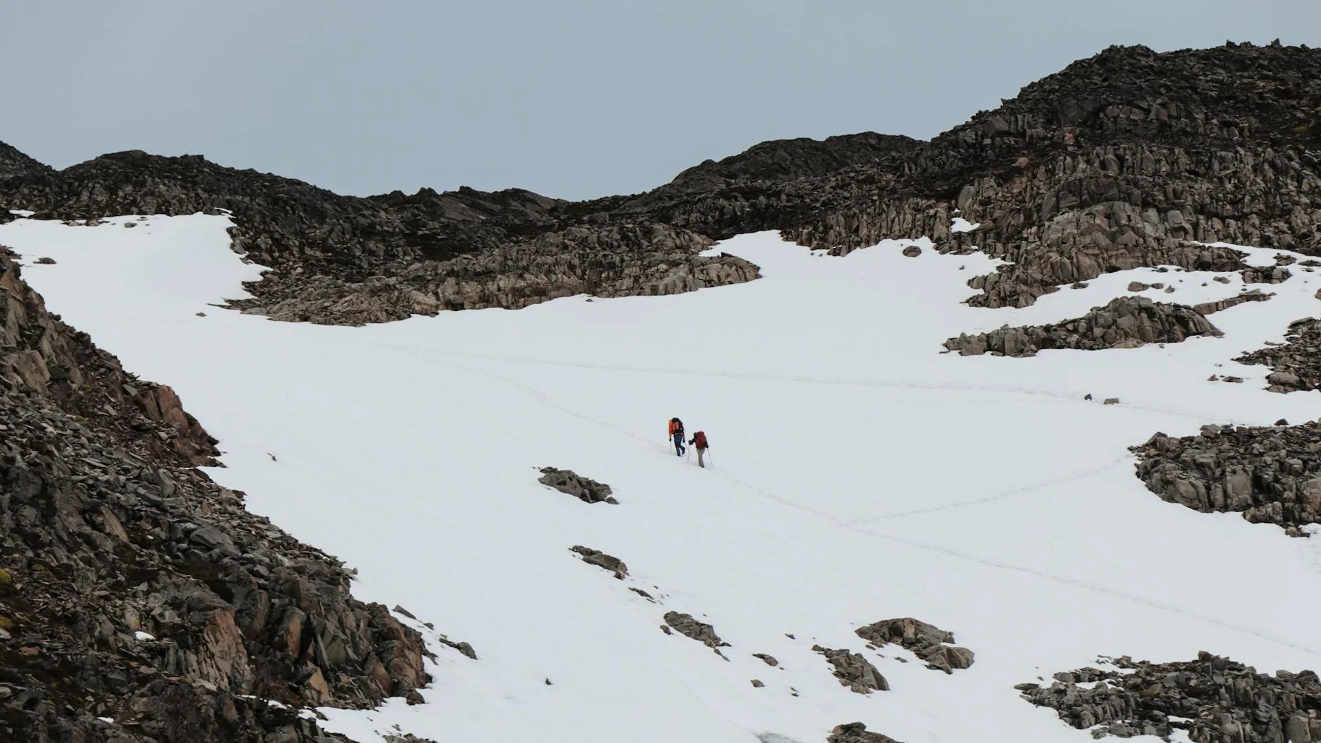 Randonneur en raquettes sur sentier de montagne enneigé avec paysage hivernal