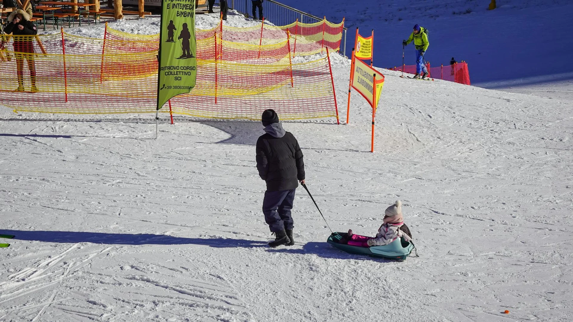 Enfants jouant dans la neige avec luge en station de ski familiale montagne