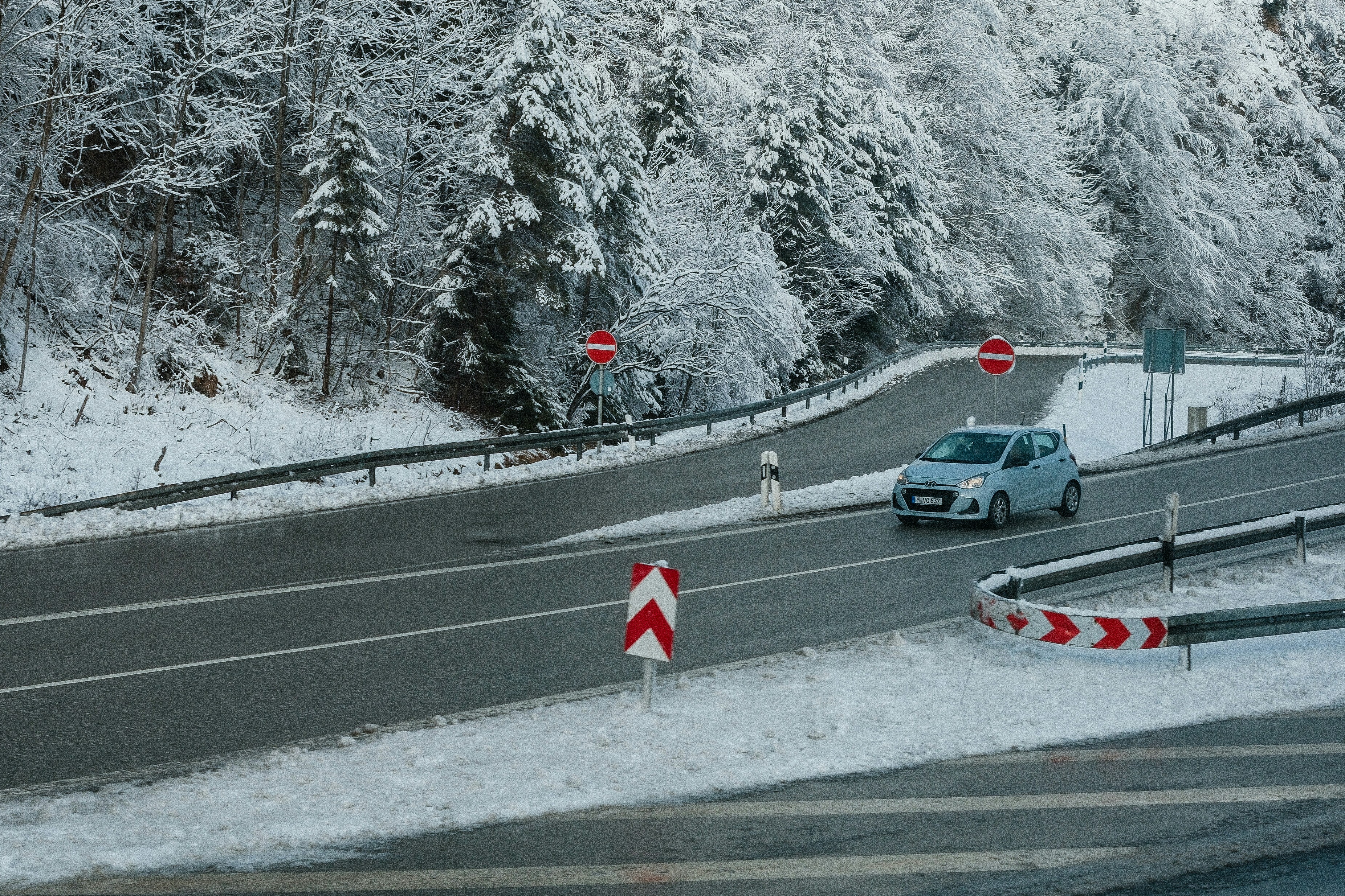 Voiture circulant sur une route de montagne enneigée en hiver